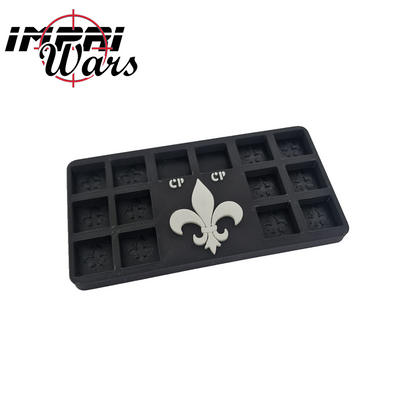 Consola de dados negra rectangular con casillas y flor de lis blanca.